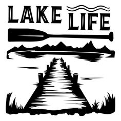 a lake life sign with a paddle on the water and mountains in the back ground