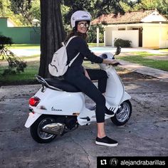 a woman sitting on top of a white scooter