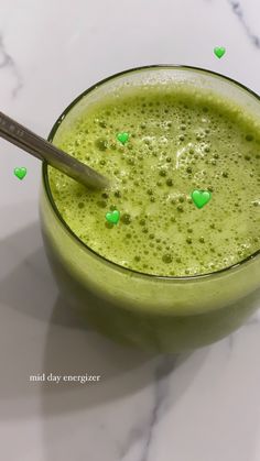 a green smoothie in a glass with hearts on it