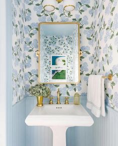 a white sink sitting under a mirror in a bathroom next to a wall mounted faucet