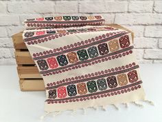 two blankets sitting on top of wooden pallets in front of a white brick wall