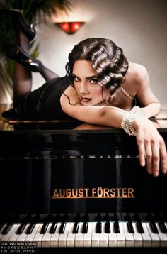 a woman leaning on the edge of a piano with her hand on top of it