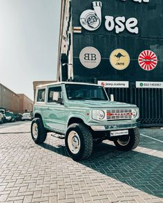 a green truck parked in front of a building