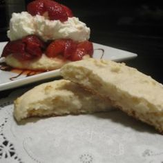 two desserts are sitting on the table with white doily and one is half eaten