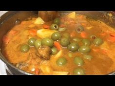 a pot filled with stew and olives on top of a stove