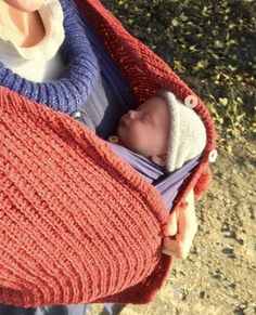 a woman holding a baby wrapped in a blanket