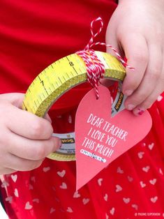 a person holding a tape measure and heart shaped ornament