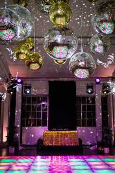 disco balls are hanging from the ceiling above a dance floor