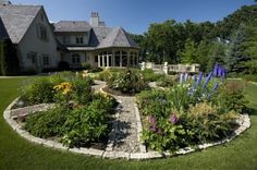 a circular garden in front of a large house