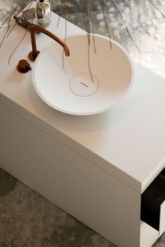 a white sink sitting on top of a counter next to a brush and toothbrush