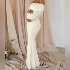 a pregnant woman in a white gown posing for the camera