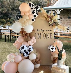 balloons are arranged in the shape of cows and flowers on display at a farm themed birthday party