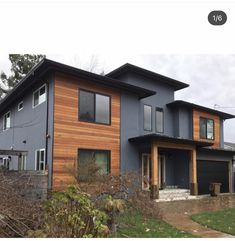 a two story house with wood siding on the front and side of it's windows