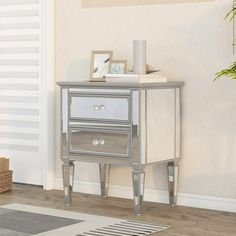 a silver and white side table in a living room with a potted plant next to it