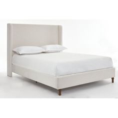 a white bed with two pillows on top of it