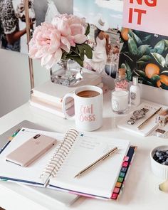 a white desk topped with a cup of coffee next to a notepad and pen