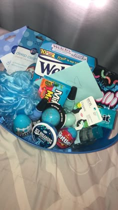 a blue tray filled with various items on top of a bed