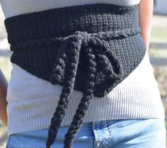 a woman wearing a black crochet belt with two braids on the side