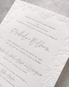 the wedding stationery is laid out on top of a white paper with gold foil