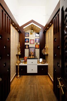 a hallway with wooden floors and decorative wallpaper on the walls, along with gold vases