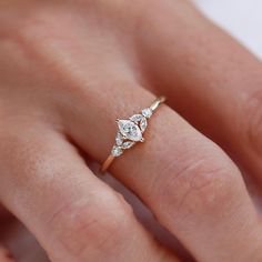 a woman's hand with a diamond ring on top of her finger and an engagement band