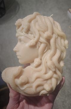 a close up of a person's hand holding a soap sculpture in front of the camera