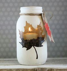 a mason jar filled with coffee beans and a lit candle