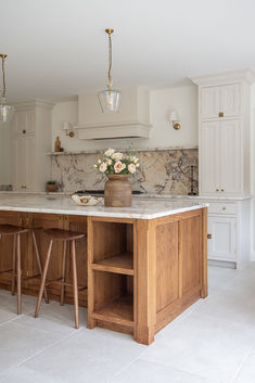 Alnwick Ivory Stone effect porcelain tiles laid in a wooden and white kitchen with marble accents. Cosy Homes