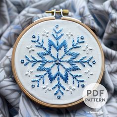 an embroidered snowflake is shown in blue and white