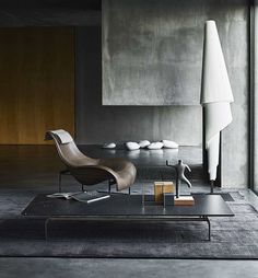 a modern living room with concrete walls and flooring, including a chair and coffee table