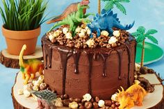 a chocolate cake topped with dinosaurs and popcorn