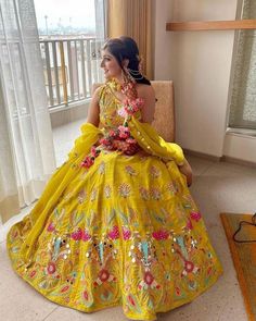 a woman in a yellow dress sitting on a chair