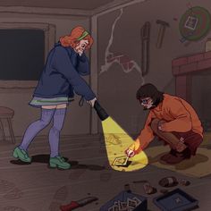 two people in a room with various items on the floor and one person holding a flashlight