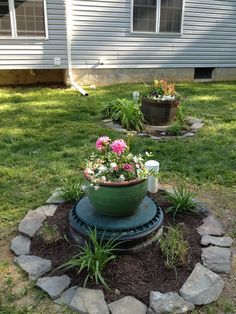 a potted planter sitting on top of a garden bed in the middle of a yard