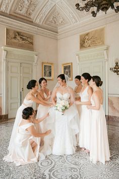 a group of women standing next to each other in front of a chandelier