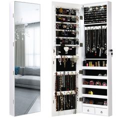 a mirrored closet with jewelry hanging from it's sides and a couch in the background