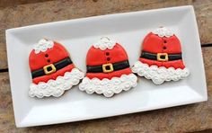 three decorated christmas cookies on a white plate