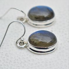 Gemstone-Labradorite Shape-Oval Stone Size- 10x14 MM Metal-925 Sterling Silver This One of a kind earrings are adorned with beautiful Labradorite Gemstone in sterling silver. About gemstone Labradorite gemstone is quite beautiful with a lovely energy that makes them a delight to surface use. Labradorite brings energy of synchronicity into your life. Labradorite is the stone of magic as it allows innate magical powers and brings out the best in people making world life more congenial. Labradorite Adjustable Oval Sterling Silver Earrings, Adjustable Round Labradorite Earrings, Round Labradorite Gemstone Earrings, Adjustable Silver Oval Earrings, Gemstone Earrings With Oval Pendant For Gifts, Silver Gemstone Oval Pendant Earrings, Oval Pendant Gemstone Earrings For Gift, Oval Silver Gemstone Earrings, Sterling Silver Oval Cabochon Earrings Gift