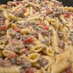 a pan filled with pasta and meat covered in sauce