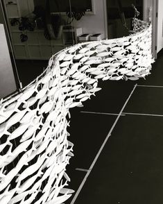 a black and white photo of some sort of structure with long strips of paper hanging from it's sides