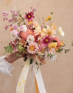 a bouquet of flowers with ribbons tied around it