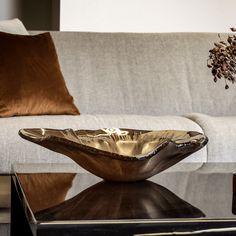 a living room with a couch, coffee table and vase on top of the table