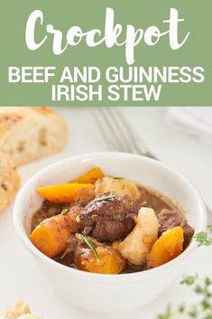 a white bowl filled with beef and guinness irish stew next to bread on a table