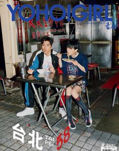 two boys sitting at a table eating food in front of an advertisement for yologirl