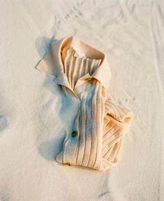 a white shirt laying on top of snow covered ground