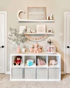 a white shelf filled with lots of toys next to a wall mounted letter on the wall