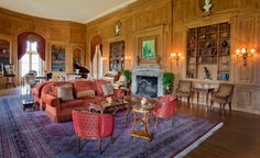 a living room filled with lots of furniture next to a fireplace and bookshelves