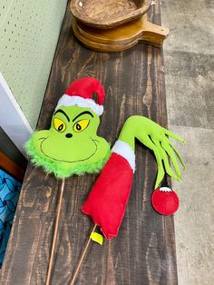 an elf's head is sitting on top of a wooden table next to a santa hat