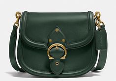 This COACH C0749 Beat Leather Saddle Crossbody Bag in Amazon Green is the perfect accessory for any woman on-the-go. Crafted from high-quality leather, it features a magnetic flap and snap closure, as well as a detachable and adjustable strap for added convenience. The bag measures 8.75\"L x 7\"H x 2.25\"D and has a 21.5\" drop strap. The bag also boasts a beautiful red sand exterior with brass gold hardware accents, including a buckle. The interior lining is also leather, adding to the bag's lu Coach Crossbody Bag With Brass Hardware, Coach Crossbody Saddle Bag For Travel, Coach Satchel With Brass Hardware, Coach Saddle Shoulder Bag With Detachable Strap, Coach Saddle Bag With Adjustable Top Handle, Coach Saddle Bag With Top Handle And Adjustable Strap, Coach Saddle Bag With Adjustable Strap And Top Handle, Luxury Green Saddle Bag With Adjustable Strap, Coach Metal Hardware Satchel Shoulder Bag