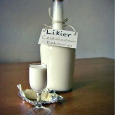 a bottle of milk sitting on top of a table next to a glass filled with milk